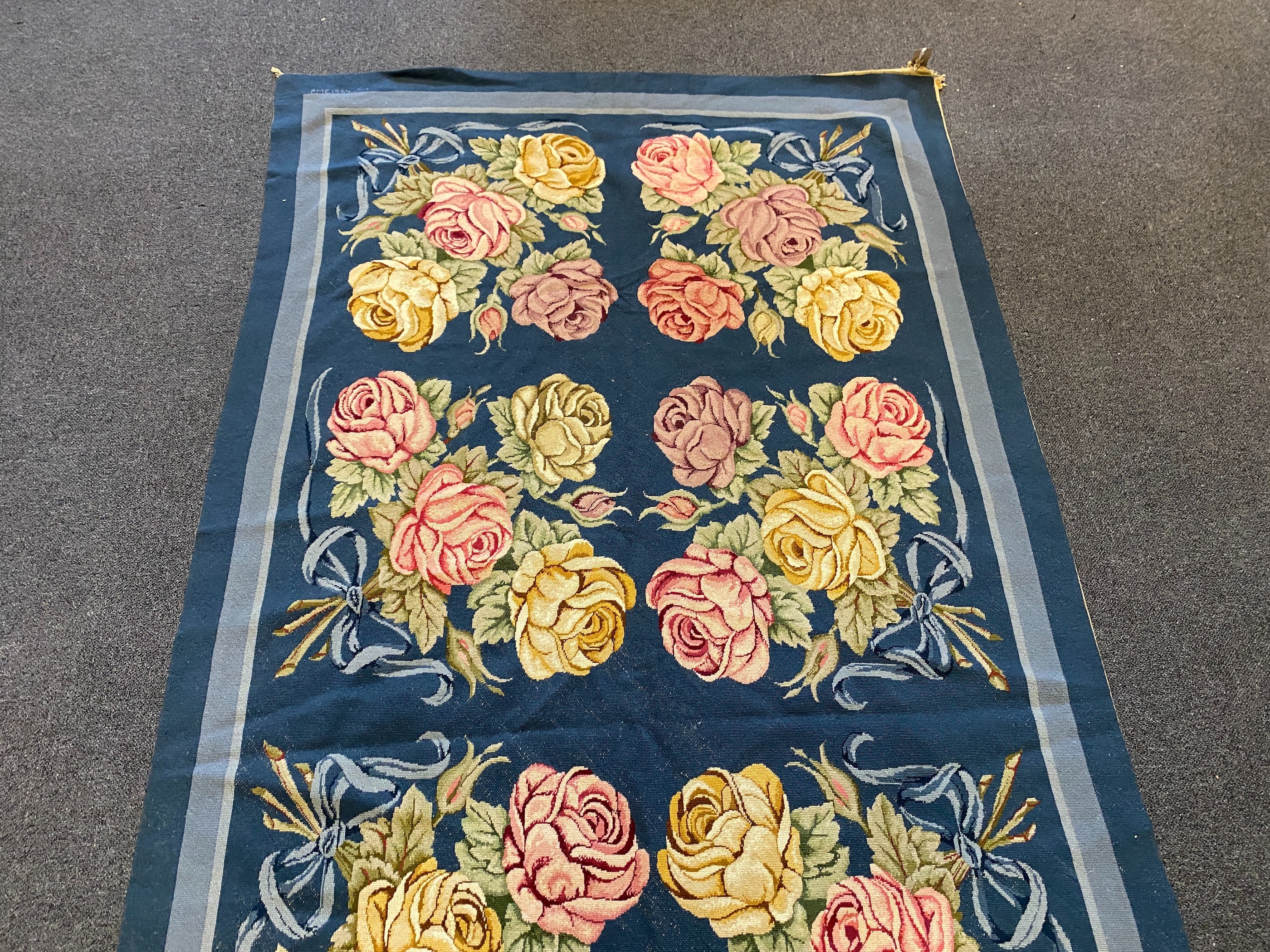 An English needlepoint blue ground carpet, 252 x 125cm